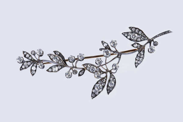 Брошь из желтого и белого металла, общим весом 18,27 грамма, содержит природные вставки из бриллиантов